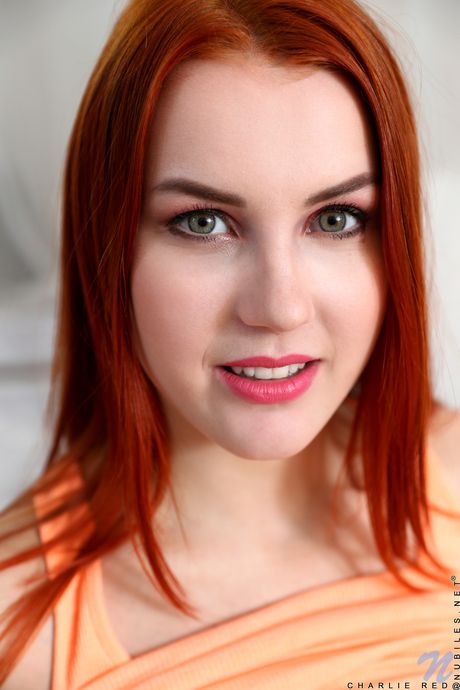 Redheaded teen Charlie Red toys her pink pussy after getting naked