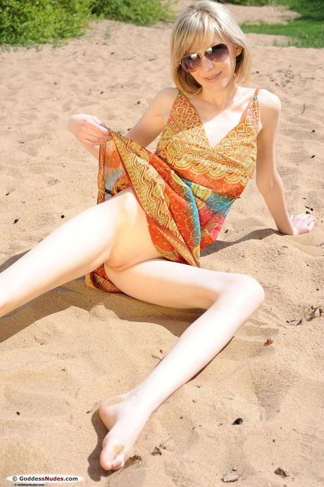 Young blonde Kristal goes naked on a patch of grass by herself