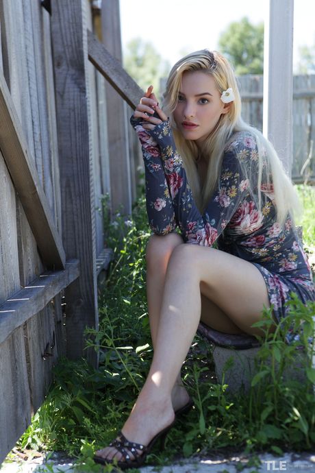 Blonde teen Kira W removes her bikini to pose nude in the shade of a tree