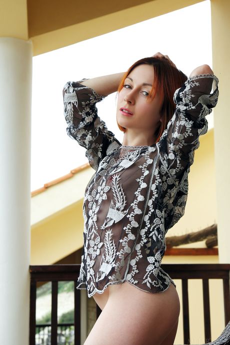 Skinny redhead Night A shows her big tits and poses naked on the balcony