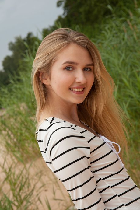 Svelte teen Lia Kate strips off her lingerie to pose nude on a rocky outcrop