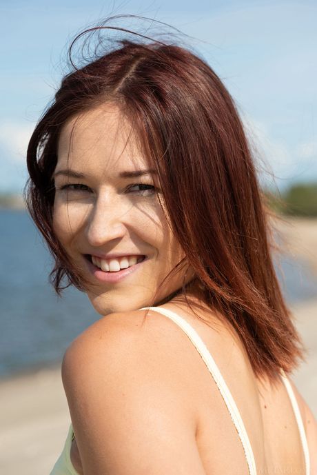 Brunette teen Mina bares it all on a dock in the middle of a lake