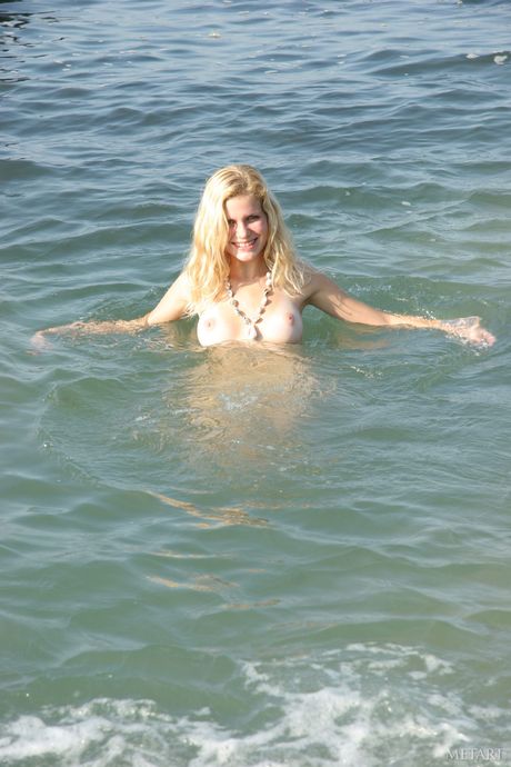 Blonde teen Nastya B models totally naked on a rocky beach