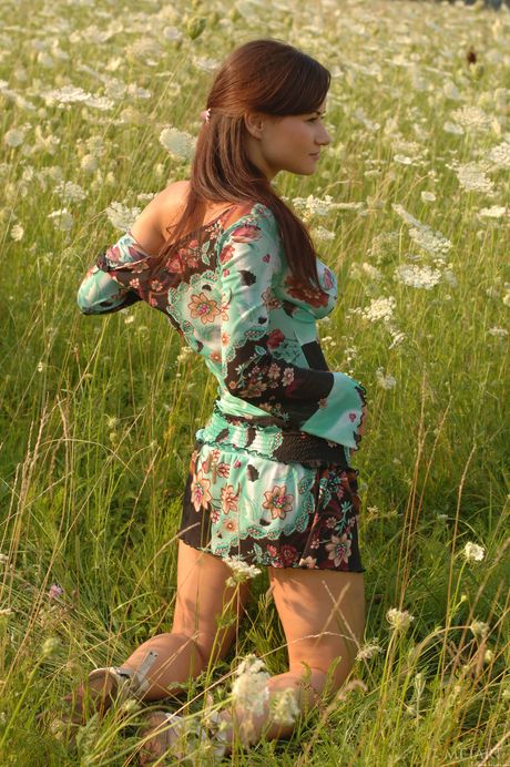 Desirable teen Ksena A strips naked in a field & shows her big tits & bald pussy