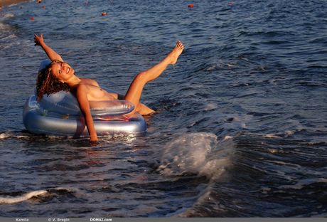 Glamour -modellen Kamila blir naken i en pöl med vatten medan du bär glasögon
