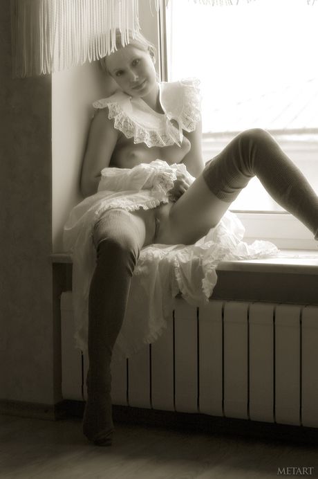 Young blonde Koika gets naked in white stockings and garters