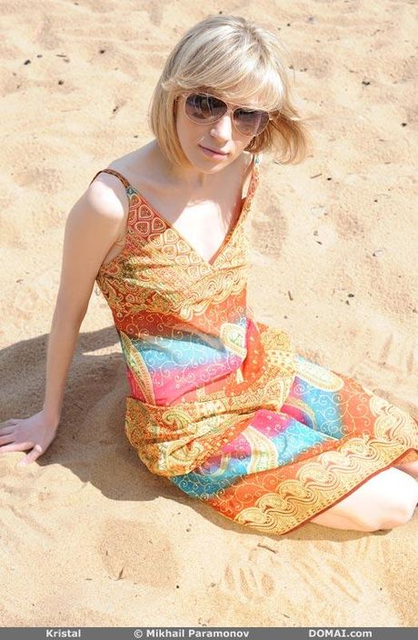 Thin teen Kristal gets naked on a sandy beach while wearing sunglasses