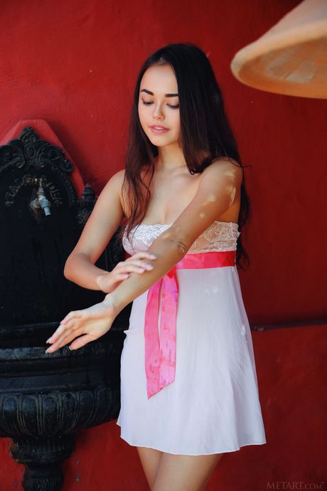 Desirable teen Li Moon removes her dress to pose nude on the steps of a fountain