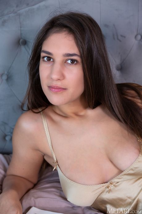 Pretty teen Oceane removes black lingerie to pose nude on her bed