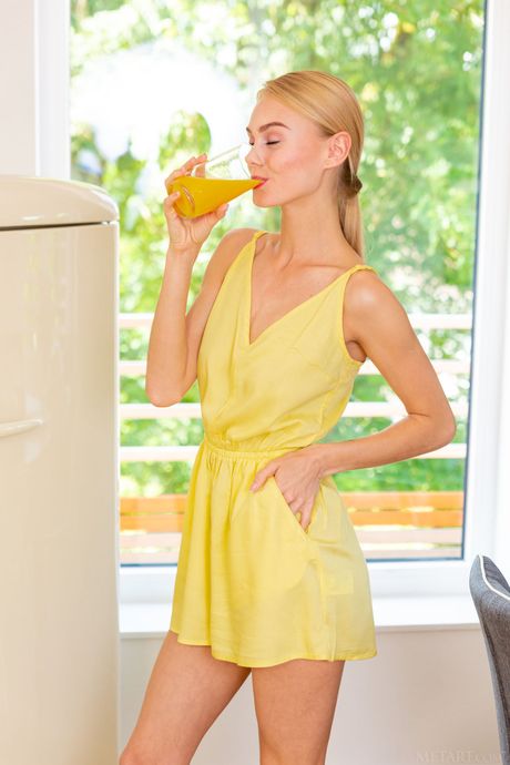 Sexy blonde teen Nancy A removes a yellow dress to get naked in the kitchen