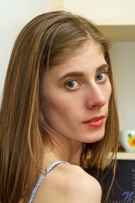 Skinny blonde Amelinda gets naked in the kitchen before masturbating