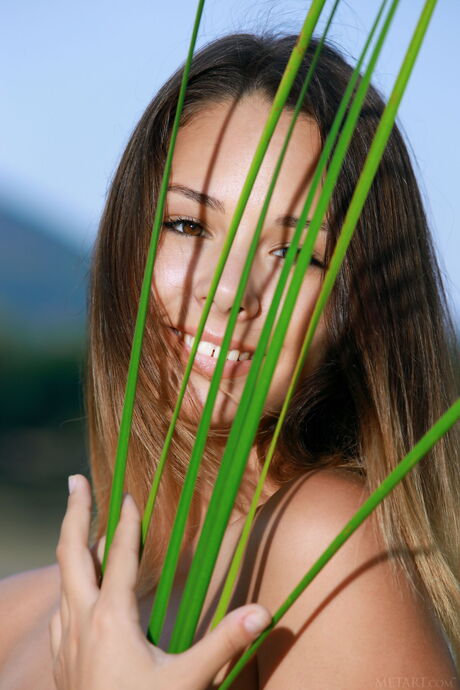 Russian lady Emmy bares her body on a blanket by a lake