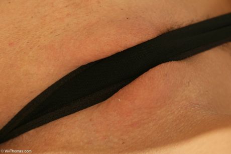 Blonde teen Vivien B gets naked before masturbating with a vibrator on a bed