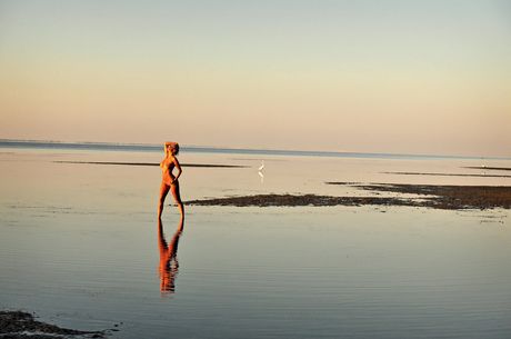 Blonde teen Marilyn Winters models totally naked on a rocky beach