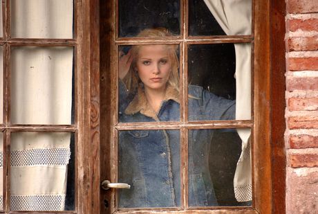 Sexy blonde Roxio gets naked on a patio and shows her bald pussy