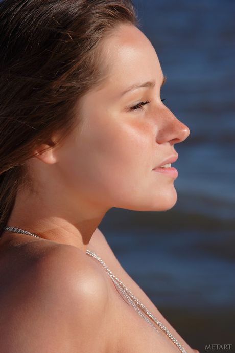 La ragazza magra Irina O dimostra la sua vagina calva e posa nuda sulla spiaggia
