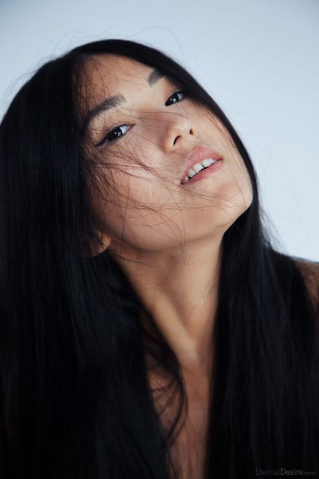 Kimiko displays her hairless pussy while bare naked on a bed