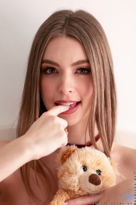 Sweet young girl Sylvie Sterling bares it all on a bed confidently