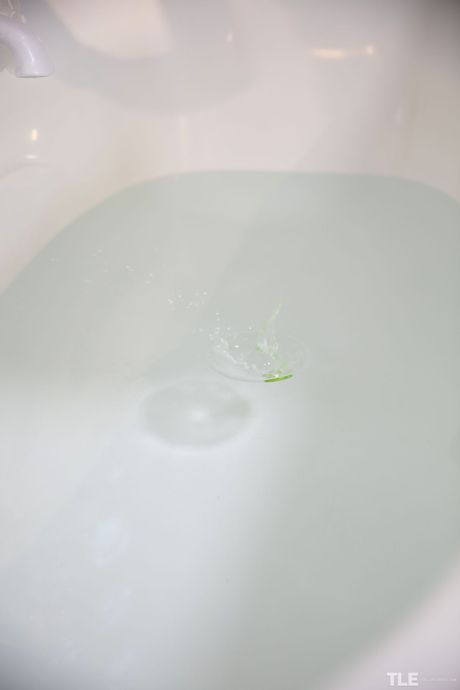 Lovely teen Lilu fingers her pussy while taking a bath in the nude