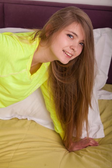 Delightful teen Sigrid removes a yellow sweater to get naked on her bed