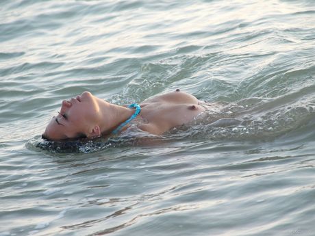 Naked teen Margo A plays in the surf at a secluded beach during solo action