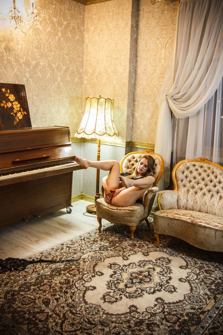 Brunette teen Izabella K removes a dress before masturbating in the nude