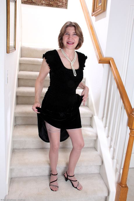 Mature woman Bossy Ryder removes her dress and stockings to pose naked