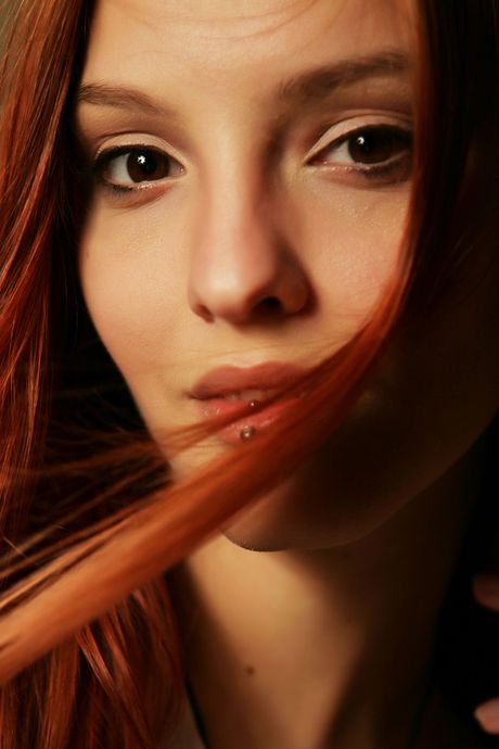 Redheaded teen Kira W gets naked without embarrassment during a solo shoot