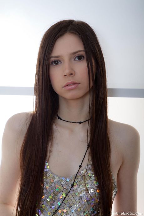 Solo girl with long hair and a nice ass gets naked in heels at a party