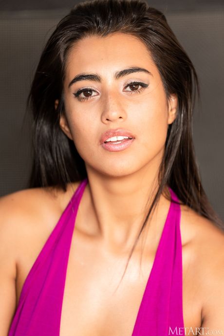 Cute teen Katherinne removes a long dress to pose nude on a chair