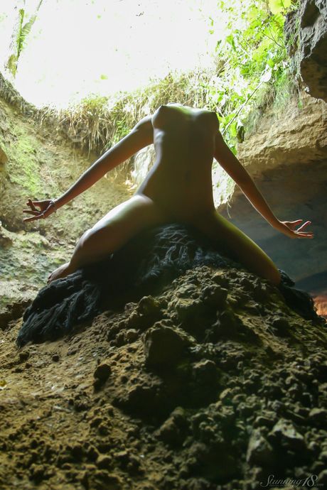 Blonde teen Quinby B poses completely naked in a sinkhole