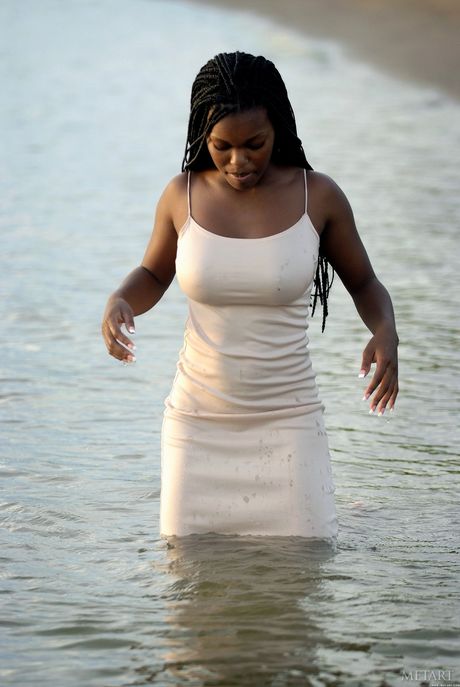 Ebony teen Deserea A presents her big tits and poses on the beach