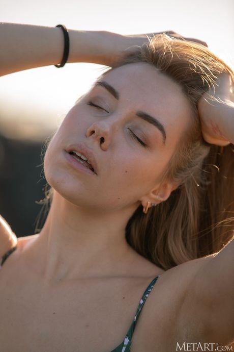 Blonde teen Ryana strips off on a sandy beach in the sun