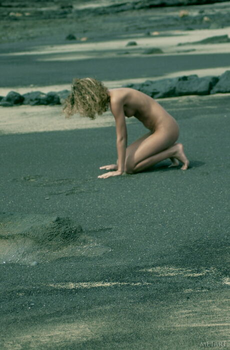 Slender teen Betty A models totally naked on a rocky beach