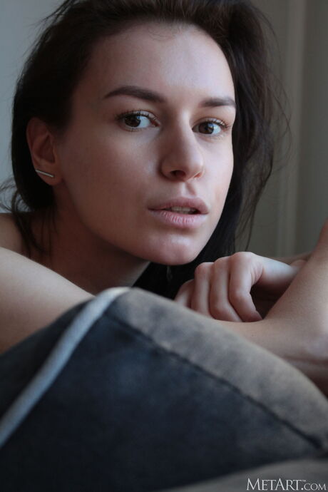 Adorable teen Taryn removes her lingerie and stockings to get naked on a bed