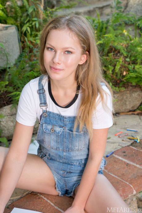 Young brunette Merelin goes nude in a garden while sketching