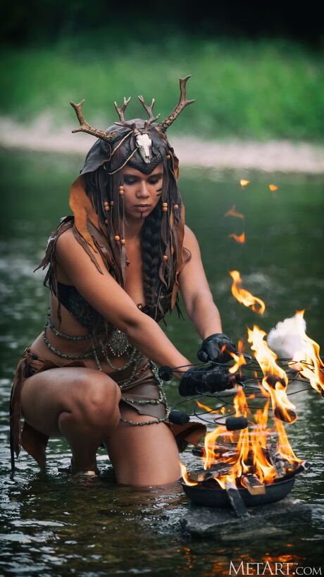 Savana is a goddess of fire in a horned headdress, wading through a river