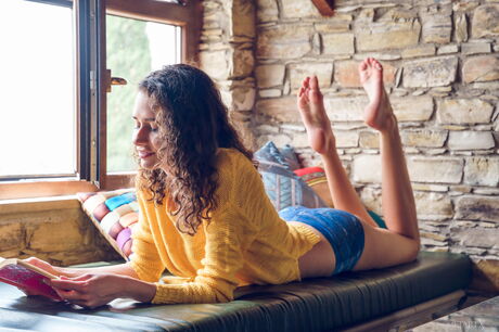 Stunning teen Cristin fingers her pussy after getting naked on a bed