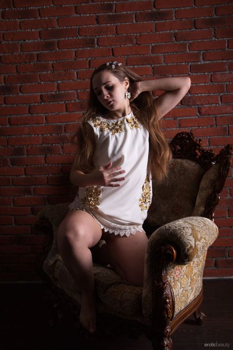 Young brunette Melira goes nude on a red brick wall