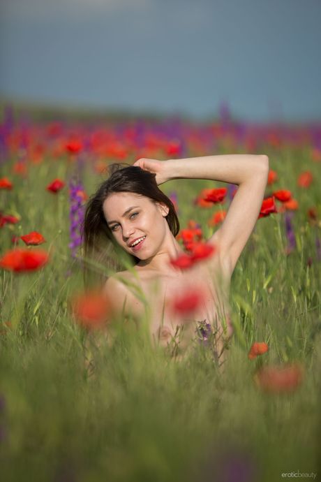 Slender teen with a beautiful face and a hot body poses naked in nature