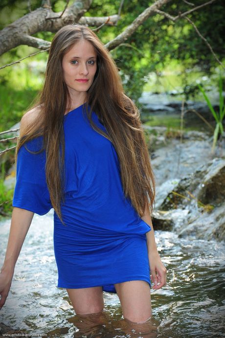 Brunette teen Daniela gets naked in the water while wearing a dress