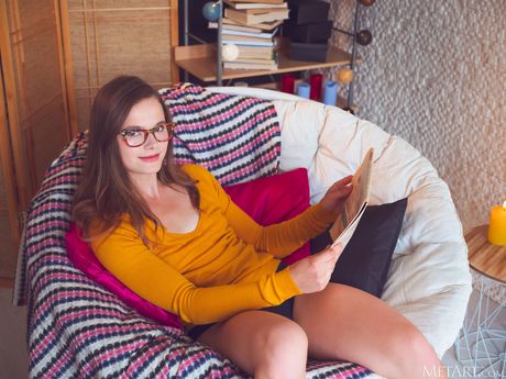 Cute teen Harley removes her glasses and panties to get naked on a rug