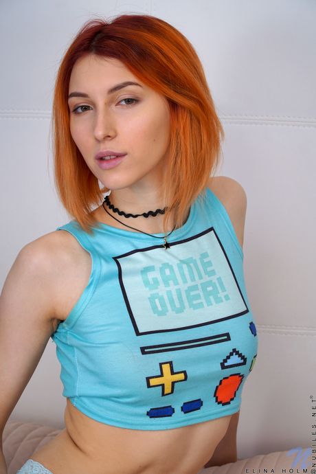 Redheaded teen Elina Holm unveils her tiny tits and rubs her clam