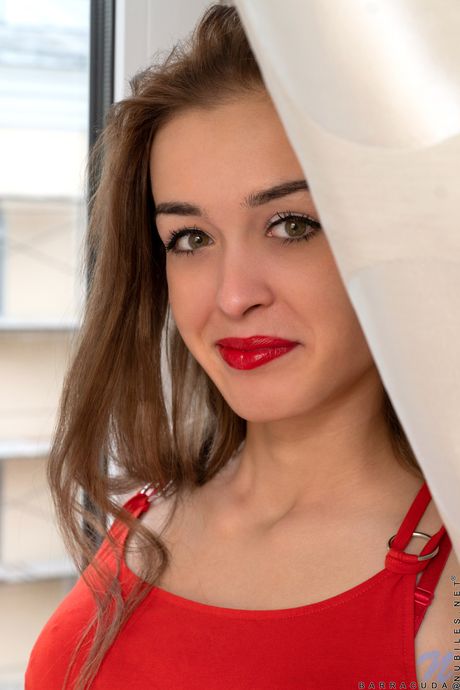 Ligh-haired teen Barracuda removes a red dress before fingering her pussy