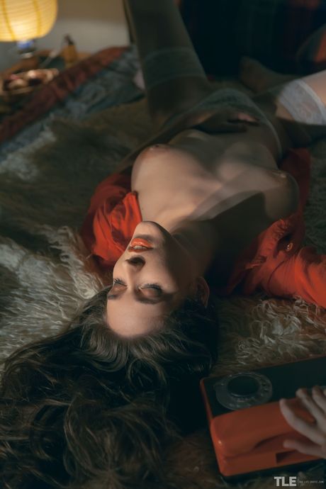 Emily J is in a state of sexual arousal as she masturbates on the bed