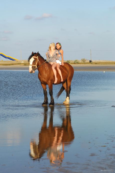 Ukrainian lesbians Katy A & Mila I pose nude on a rocky beach