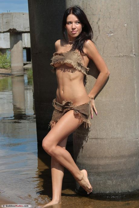 Slender teen Sabinna models totally naked in a shallow brook by herself