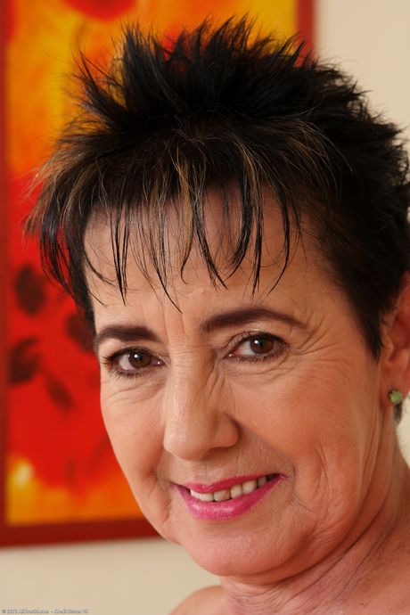 Mature granny Yvette shows her big ass and stretches her pussy