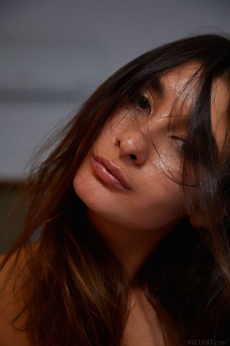 Charming teen Bambi Joli removes her dress and panties to pose nude on a stool