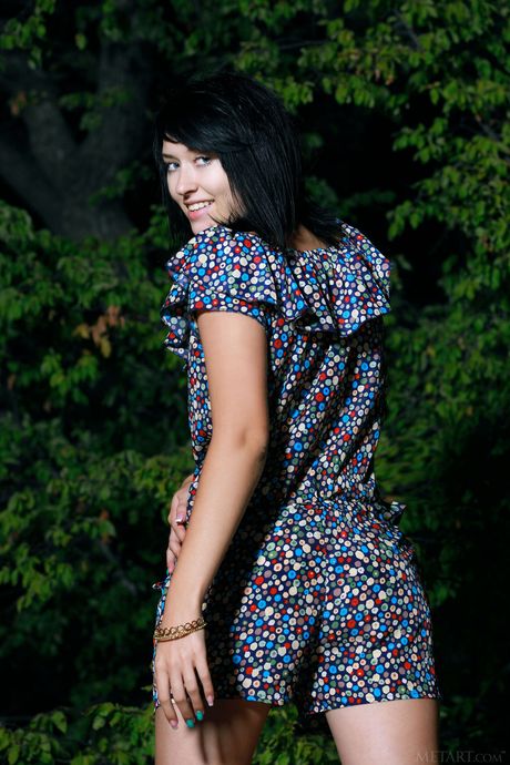 Brunette teen Ramina gets bare naked in a yard next to fir trees